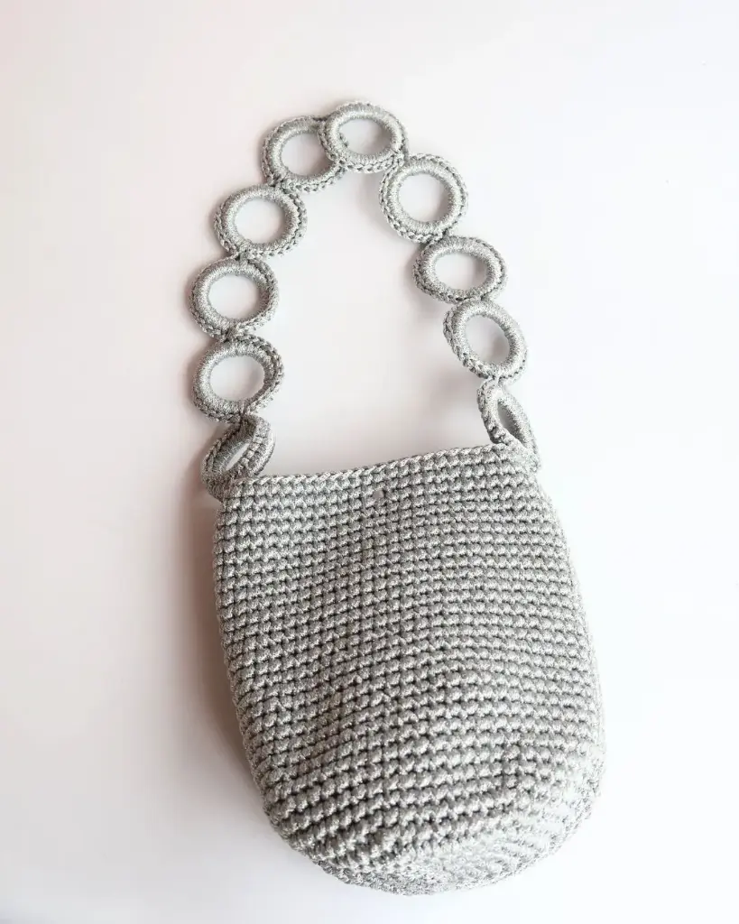 0891 - Cartera tejida aros plateada brillos 